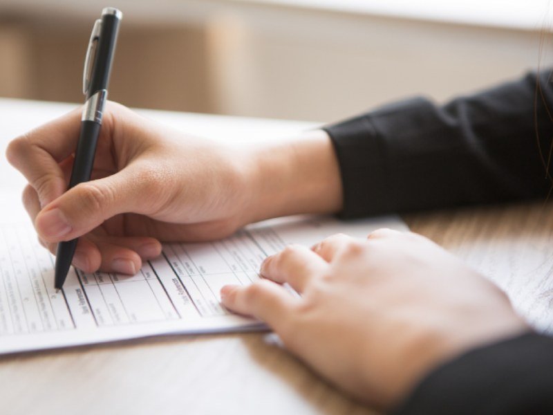 Cropped view of woman filling in application form