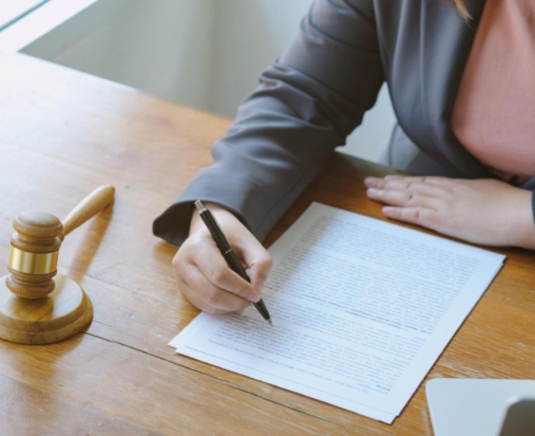Midsection of judge writing in paper while sitting on table